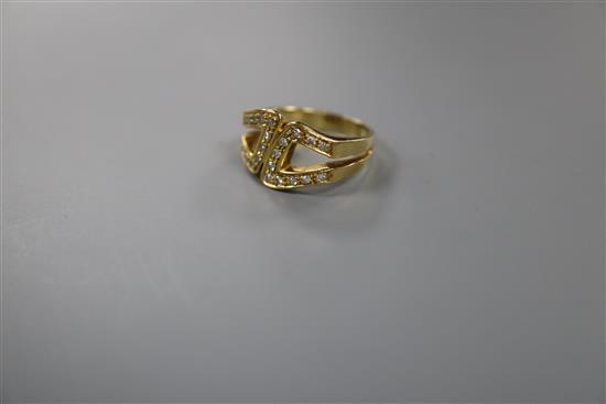 A modern 18ct gold and diamond set stylised buckle ring, size M, gross 7.8 grams.